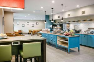cocina grande con armarios azules y comedor en Country Inn & Suites by Radisson, Madison West, WI, en Middleton