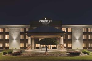 un edificio con un cartel que lee posada rural y suites en Country Inn & Suites by Radisson, Mt Pleasant-Racine West, WI, en Sturtevant