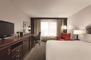Habitación de hotel con cama, escritorio y TV. en Country Inn & Suites by Radisson, Madison, AL en Madison