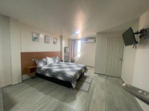 Schlafzimmer mit einem Bett, einem Fenster und einer Tür in der Unterkunft Estudio aeropuerto in Ciudad Juárez