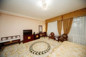 een grote kamer met een bed en een televisie bij Hotel Royal Florence in Chişinău