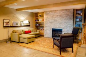sala de estar con sofá y chimenea en Country Inn & Suites by Radisson, Tuscaloosa, AL, en Tuscaloosa
