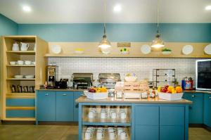 a kitchen with blue cabinets and fruits on a counter at Country Inn & Suites by Radisson, Tuscaloosa, AL in Tuscaloosa