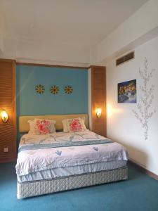 sypialnia z łóżkiem z różowymi kwiatami w obiekcie Melaka Family Beachfront w mieście Kampong Lereh