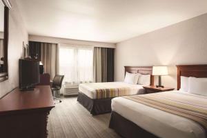 a hotel room with two beds and a television at Country Inn & Suites by Radisson, Bentonville South - Rogers, AR in Rogers