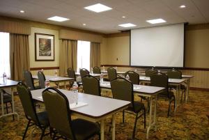 a conference room with tables and chairs and a screen at Country Inn & Suites by Radisson, Bentonville South - Rogers, AR in Rogers