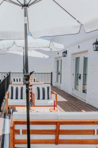 a row of tables and chairs on a deck with an umbrella at The Lighthouse Boutique Hotel in Port Isabel