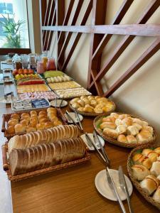 a table with many different types of bread and pastries at Muro Alto - Flat Completo MANA Resort in Porto De Galinhas