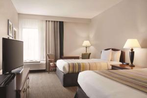 a hotel room with two beds and a flat screen tv at Country Inn & Suites by Radisson, Bryant Little Rock , AR in Bryant