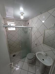 Baño blanco con aseo y lavamanos en Apto Centro Floripa 06, en Florianópolis