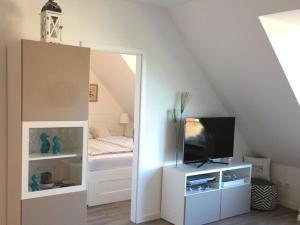 ein Wohnzimmer mit einem TV und einem Bett in der Unterkunft Am Mühlenteich 2 in Timmendorfer Strand