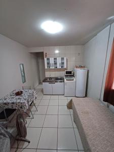 eine kleine Küche mit weißen Geräten und einem Tisch in der Unterkunft Apto Centro Floripa 02 in Florianópolis