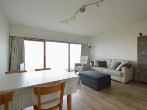a living room with a table and a couch at West31 with beautiful sea views in Oostduinkerke