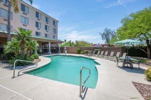 a swimming pool with chairs and a table and a building at Country Inn & Suites by Radisson, Mesa, AZ in Mesa