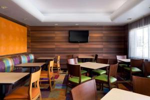 un restaurante con mesas y sillas y TV de pantalla plana en Country Inn & Suites by Radisson, Phoenix Airport, AZ en Phoenix