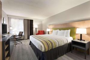 a hotel room with a large bed and a desk at Country Inn & Suites by Radisson - Flagstaff East Route 66 in Flagstaff