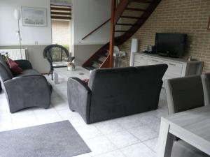 sala de estar con 2 sillas y TV en Holiday apartment Zonnewende 16, en Sint Maartensvlotbrug