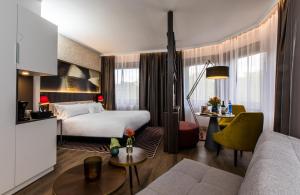 ビルバオにあるNYX Hotel Bilbao by Leonardo Hotelsのベッドとソファ付きのホテルルーム