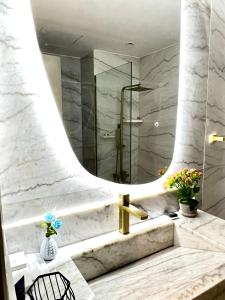 een badkamer met een wastafel en een spiegel bij Brand new Modern Studio High Floor near Burj in Dubai