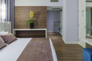 a bedroom with a bed and a vase with a plant at Radisson Hotel Curitiba in Curitiba