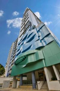 un grand bâtiment en verre avec un ciel bleu en arrière-plan dans l'établissement Park Inn by Radisson Santos, à Santos