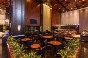 a restaurant with tables and chairs and a bar at Radisson Hotel Curitiba in Curitiba