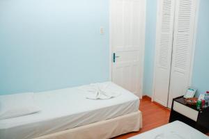 a bedroom with two beds and two white doors at Pousada Arco-Íris in Lambari