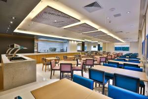 uma sala de jantar com mesas e cadeiras e uma cafetaria em Park Inn by Radisson Santos em Santos