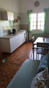 een woonkamer met een keuken, een tafel en een bank bij Les coquelicots. in Mirepoix
