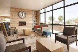 a living room with a clock on the wall at University Hotel Davis Area by IHG in Dixon