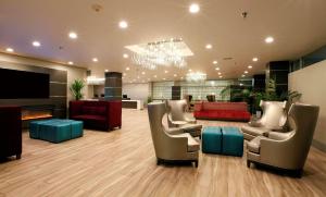 a lobby with couches and chairs and a fireplace at Radisson Hotel Oakland Airport in Oakland