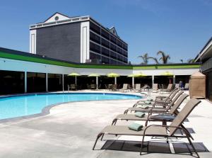 - une rangée de chaises longues à côté de la piscine dans l'établissement Radisson Hotel Oakland Airport, à Oakland