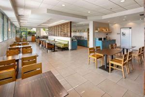un restaurante con mesas y sillas y una cafetería en Country Inn & Suites by Radisson, San Diego North, CA, en Mira Mesa