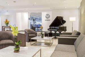 sala de estar con piano y sofá en Radisson Bogota Metrotel en Bogotá