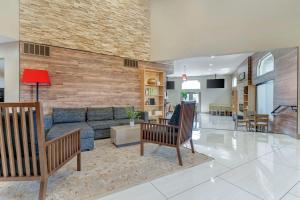 Country Inn & Suites by Radisson, Vallejo Napa Valley, CA في فاليجو: غرفة معيشة مع أريكة وطاولة