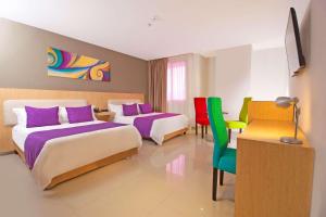 a hotel room with two beds and colorful chairs at Radisson Diamond Barranquilla in Barranquilla