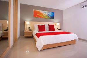 a bedroom with a large bed with red pillows at Radisson Diamond Barranquilla in Barranquilla
