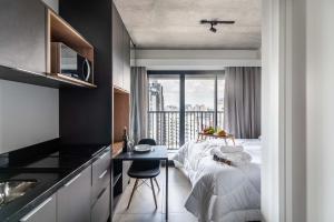 a hotel room with a bed and a balcony at VN Ueno in Sao Paulo
