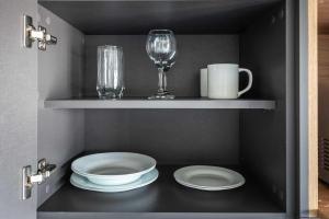 a shelf with plates and glasses and a wine glass at VN Ueno in Sao Paulo +92 photos