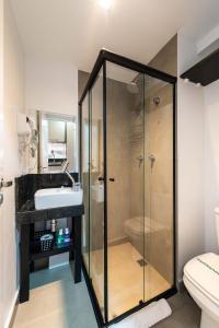a bathroom with a glass shower and a sink at VN Ueno in Sao Paulo