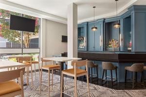 a restaurant with tables and chairs and a bar at Radisson Hotel Sunnyvale - Silicon Valley in Sunnyvale