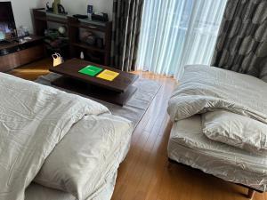 Sala de estar con 2 camas y mesa de centro en Villa Souan - Vacation STAY 15588 en Mobara