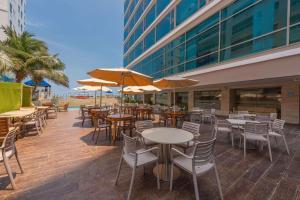 un restaurante al aire libre con mesas, sillas y sombrillas en Radisson Cartagena Ocean Pavillion Hotel en Cartagena de Indias