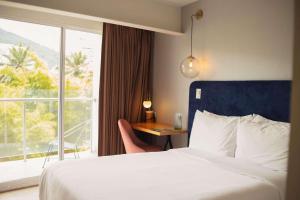 una camera d'albergo con letto e finestra di Faranda Collection Cali, a member of Radisson Individuals a Cali