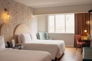 una camera d'albergo con due letti e una finestra di Faranda Collection Cali, a member of Radisson Individuals a Cali