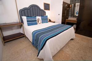 a bedroom with a large bed with blue pillows at Hotel Casa La Factoria by Faranda Boutique, a member of Radisson Individuals in Cartagena de Indias