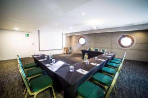 una sala de conferencias con una mesa larga y sillas verdes en Radisson Blu Acqua Hotel & Spa Concon, en Concón