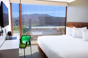 um quarto de hotel com uma cama e uma grande janela em Park Inn by Radisson Los Olivos de Vallenar em Vallenar