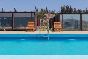 a pair of chairs and a swimming pool at Park Inn by Radisson Los Olivos de Vallenar in Vallenar
