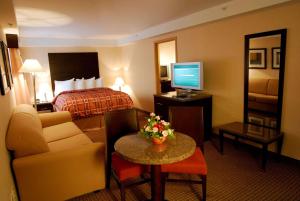 a hotel room with a bed and a living room at Radisson Hotel Red Deer in Red Deer